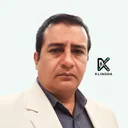 Retrato de Cristian Ávalos, con chaqueta crema y camisa de cuadros, sobre fondo claro con el logo de Klinoda