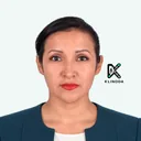 Retrato de Mirella Llanga, con chaqueta azul petróleo y blusa blanca, sobre fondo claro con el logo de Klinoda